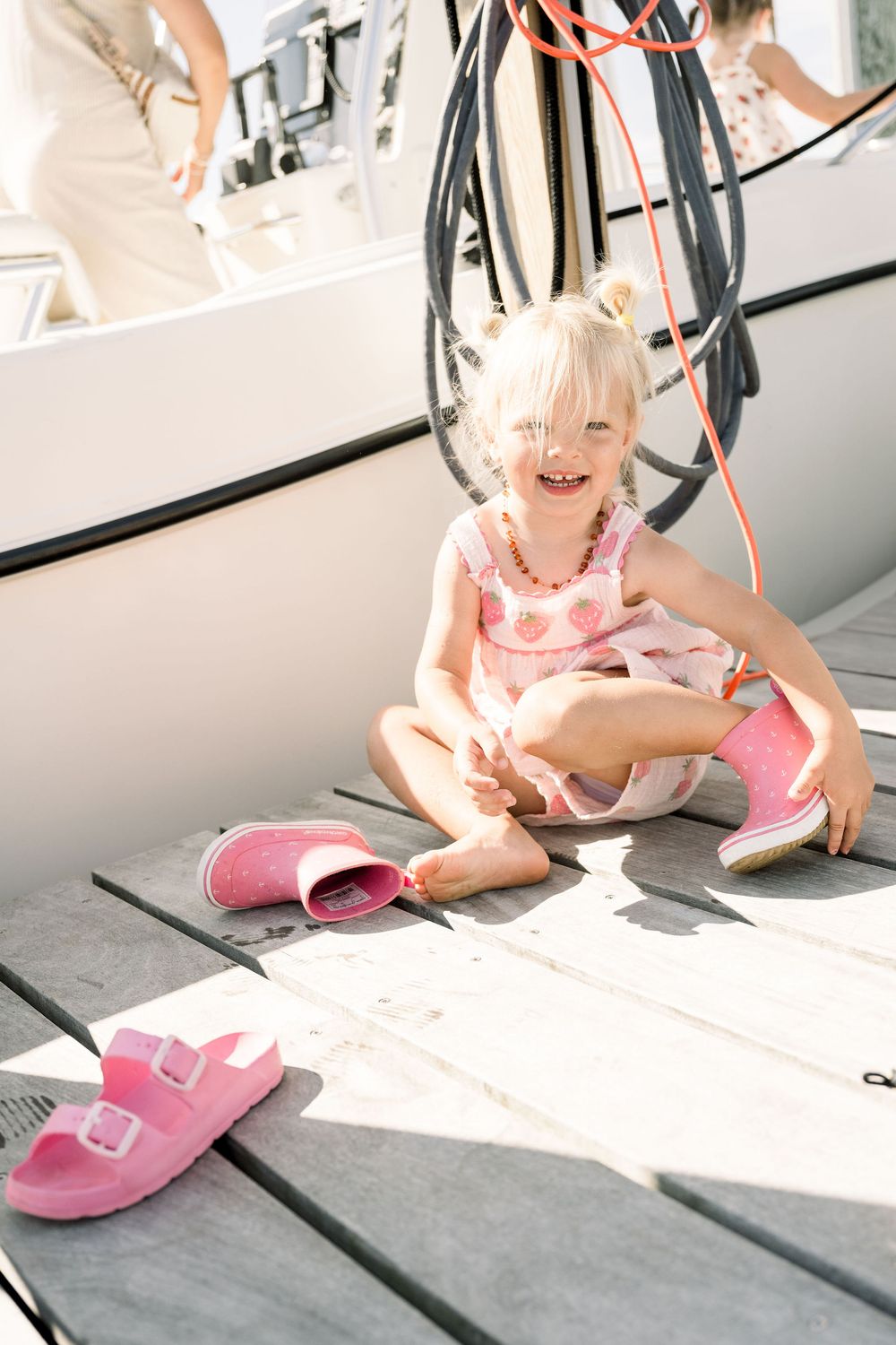 A sequence of images showing pink slippers being worn and examined on a wooden deck in natural lighting.