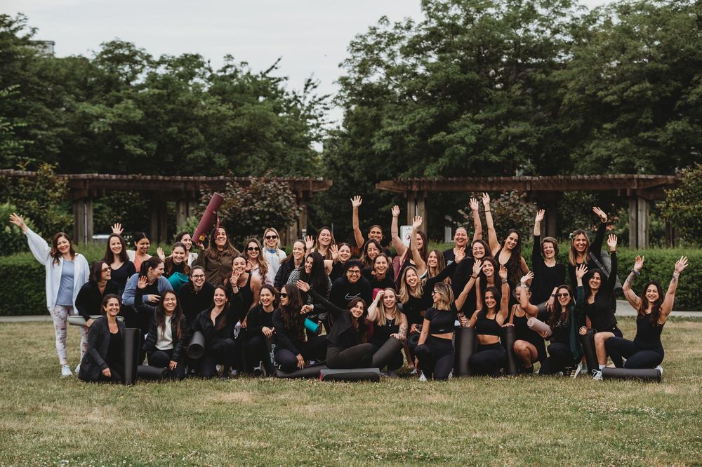 Large group photo of fitness participants posing together outdoors.