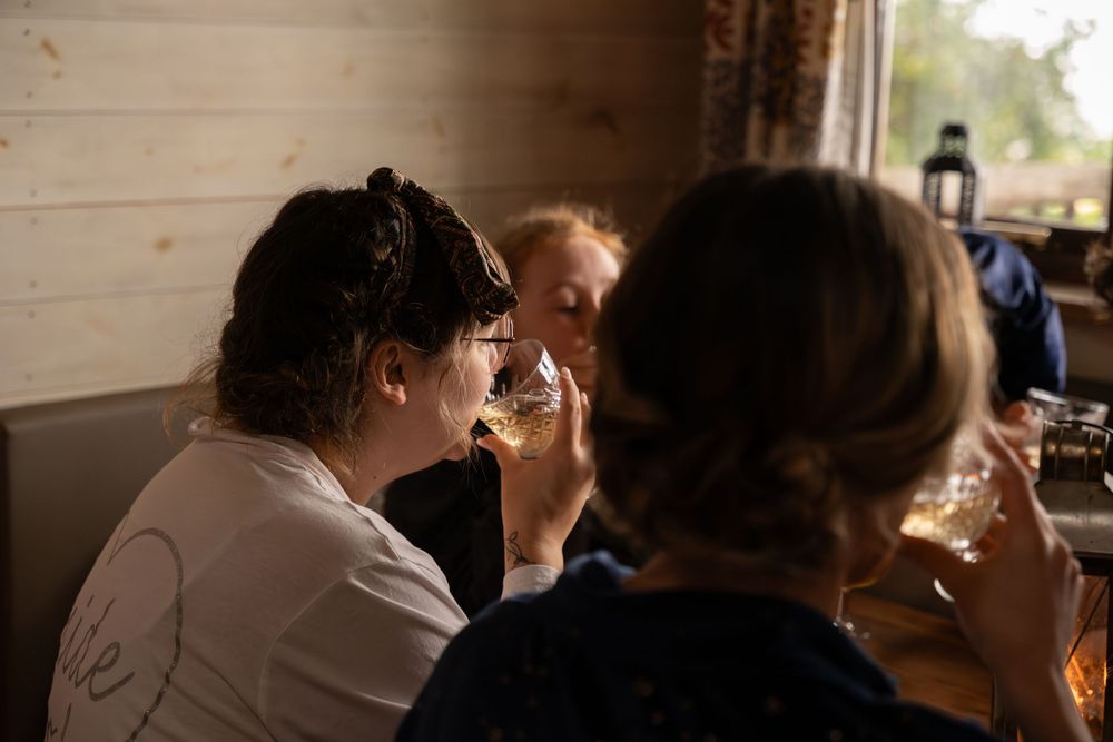 Wedding party members share intimate moments during preparation in a rustic wooden cabin setting.