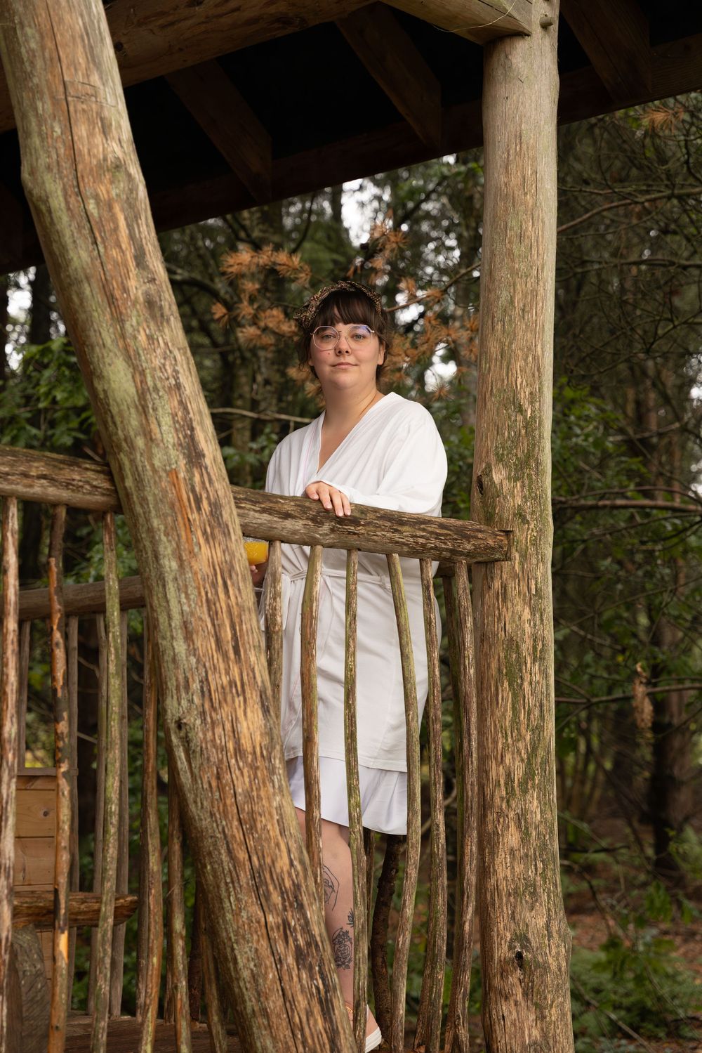Wooden platform constructed between tall tree trunks in a forest setting.