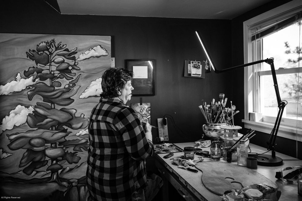 Black and white panoramic sequence showing an artist's workspace with drawing materials and equipment on a desk.