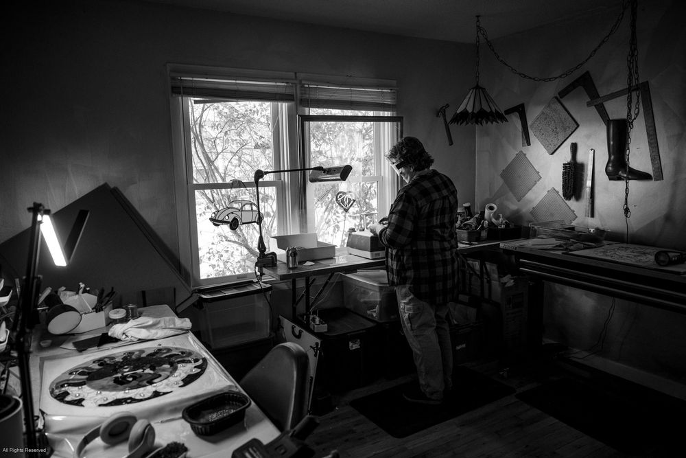 A collection of black and white photographs showing various interior workspaces and studio environments.
