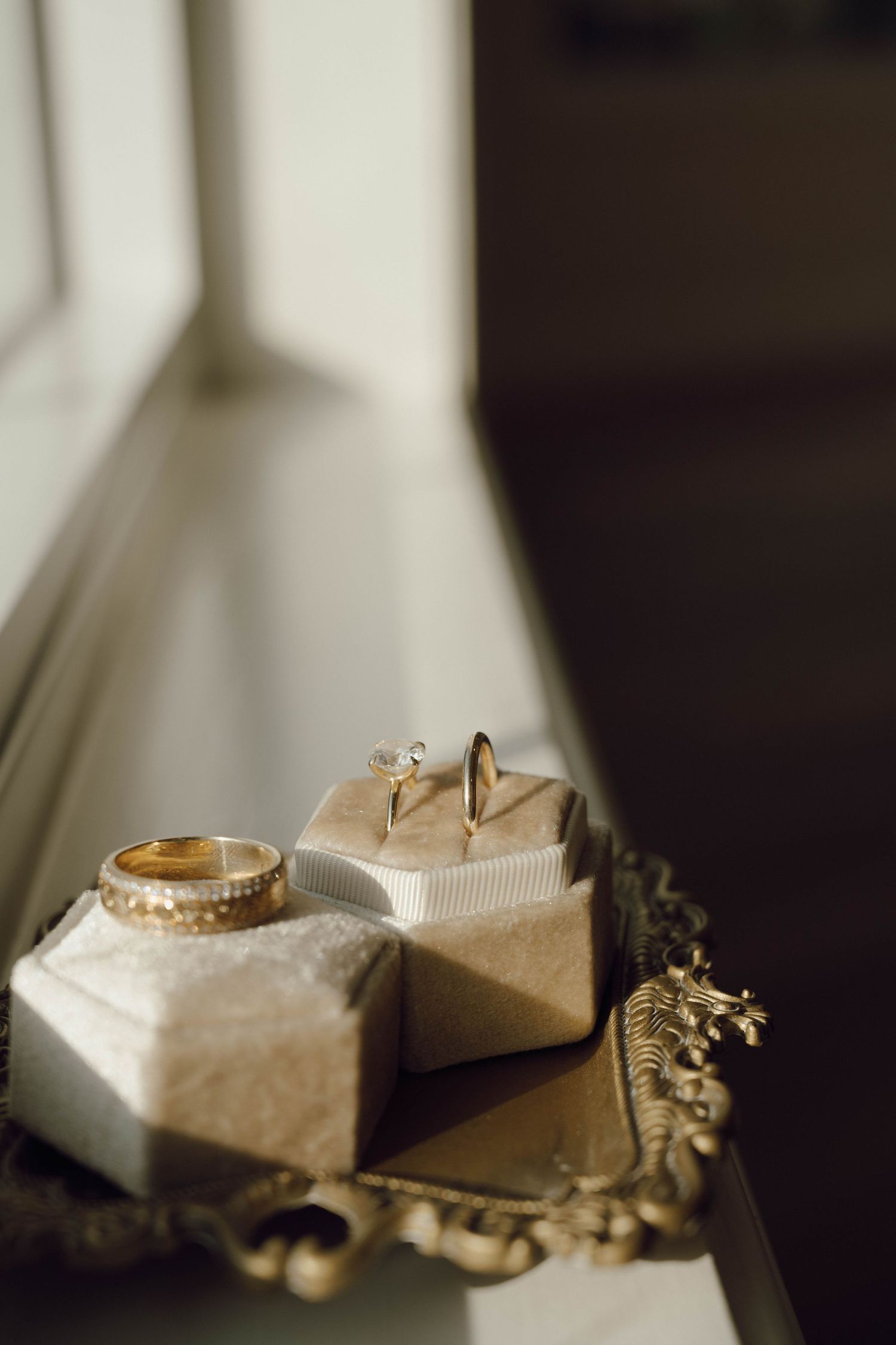 Soft focus still life of delicate objects arranged on a white surface beneath a chandelier.