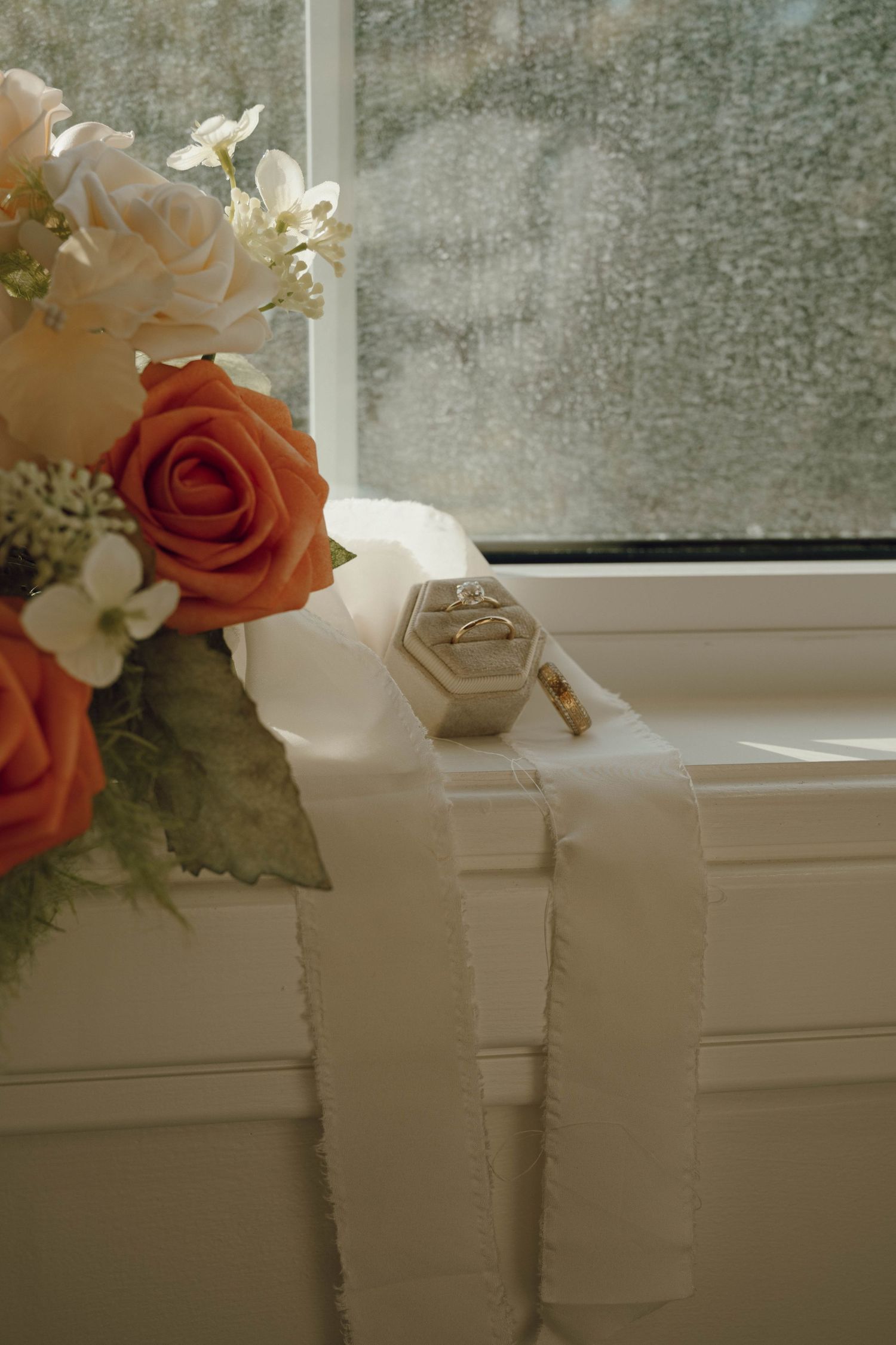 Decorative floral arrangements with roses and white flowers displayed on a windowsill.
