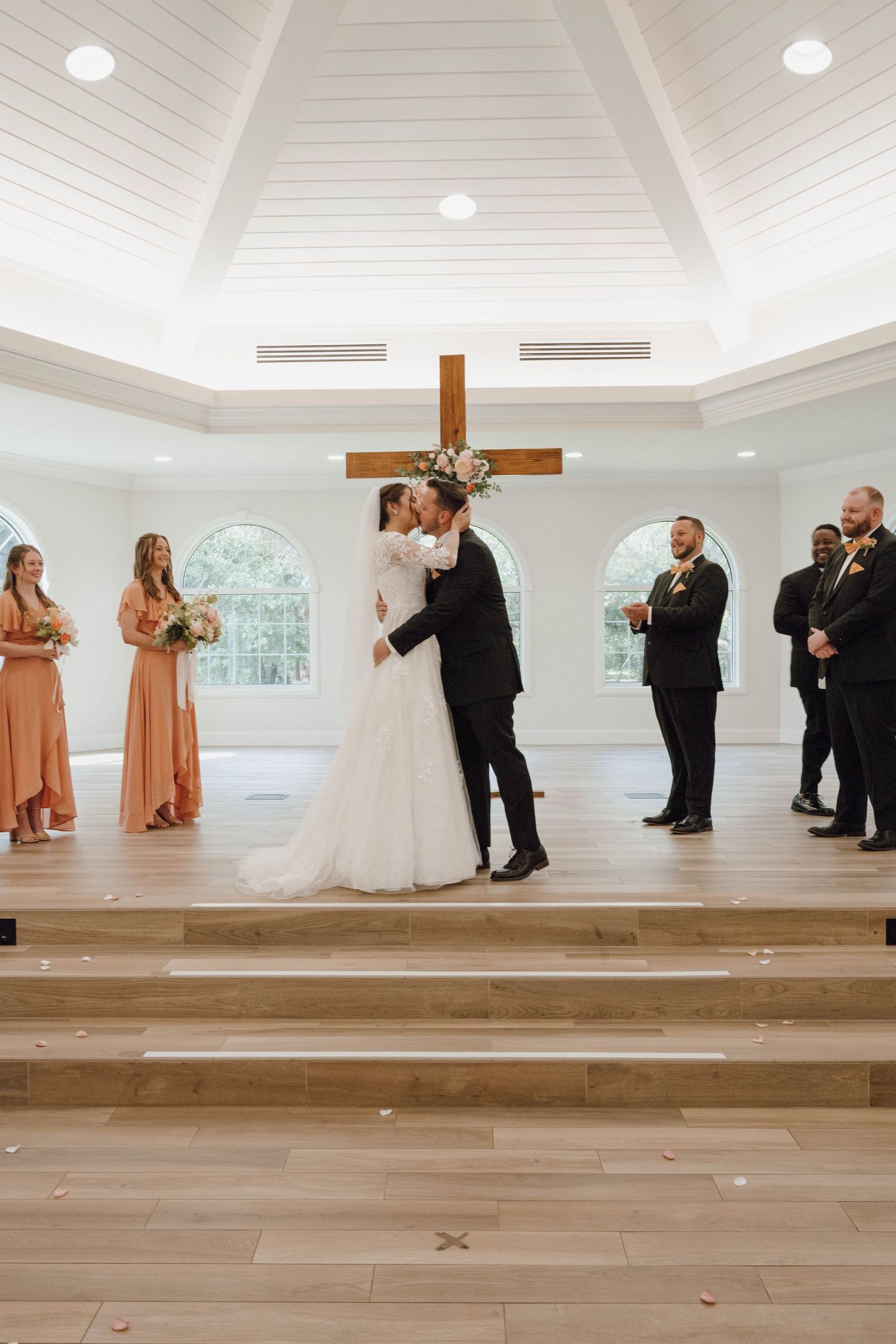 First dance sequence in a modern chapel with white vaulted ceilings and wooden floors.