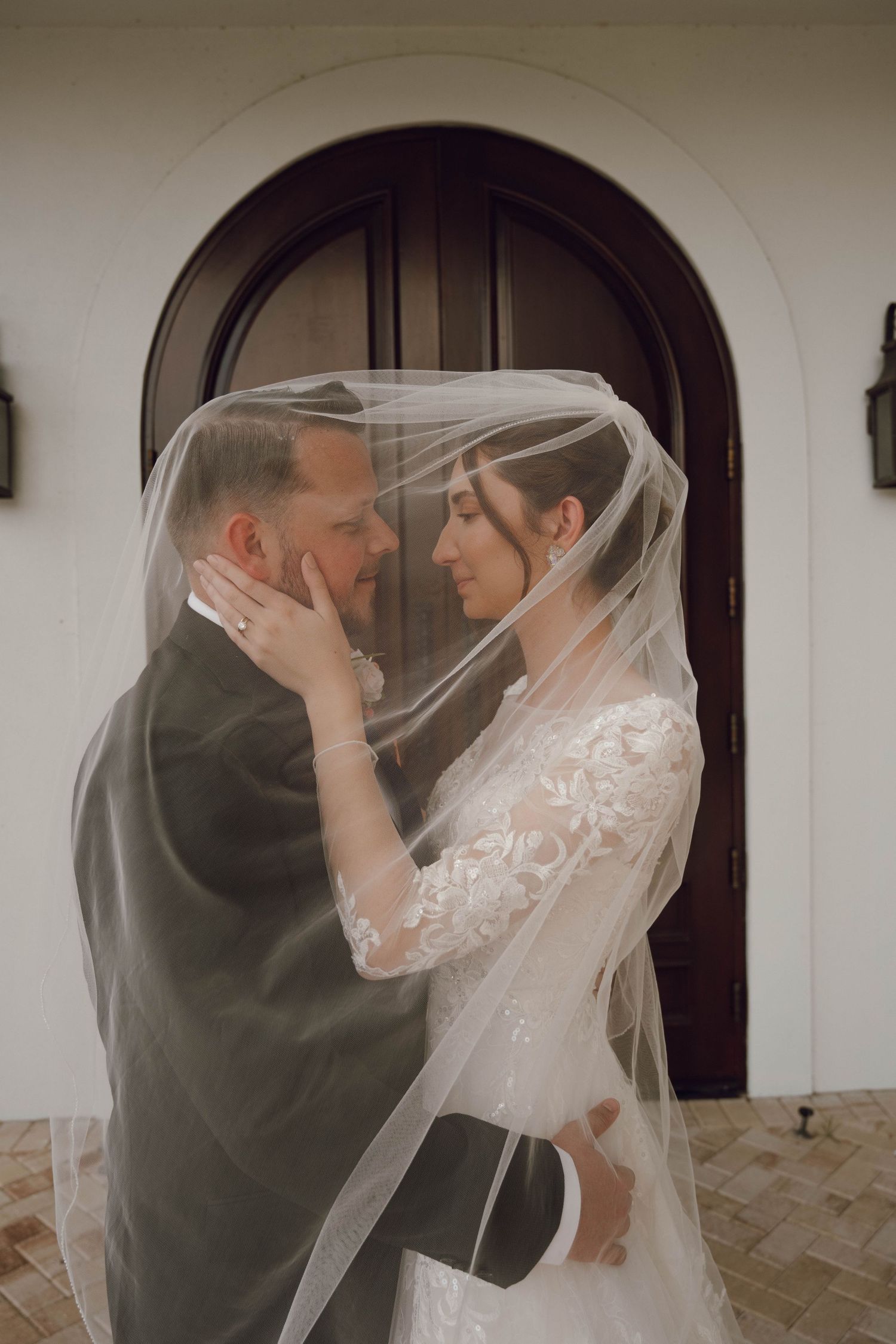 Wedding couple sharing intimate moments under a delicate white veil in multiple romantic shots.