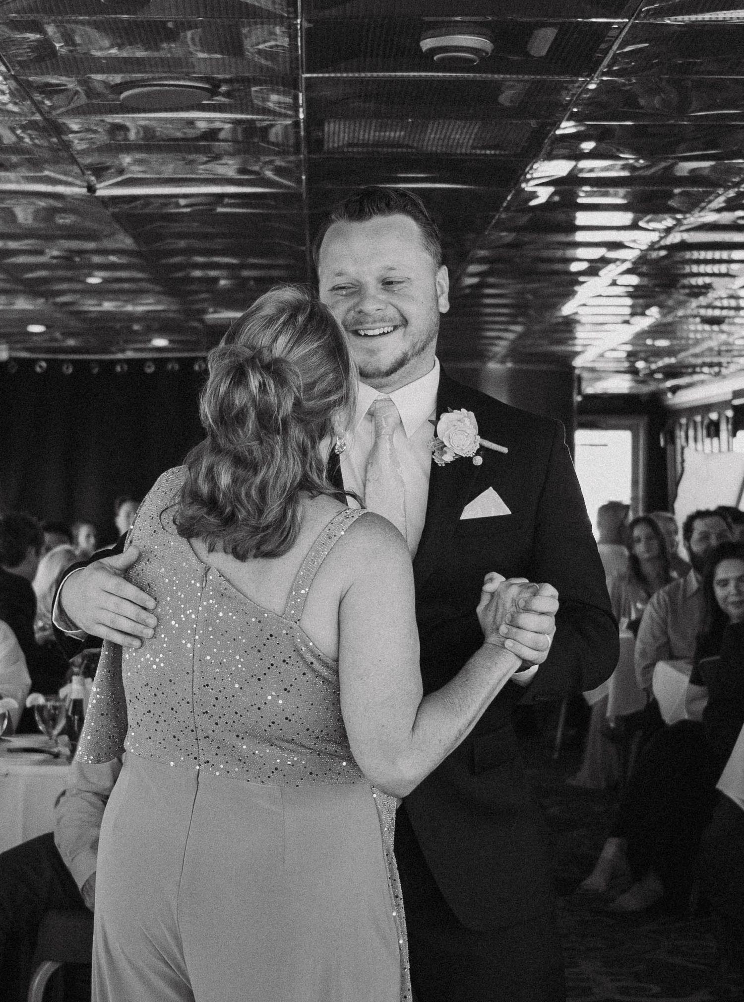 A couple shares a romantic dance moment at their wedding reception, with the bride wearing a sparkly dress.