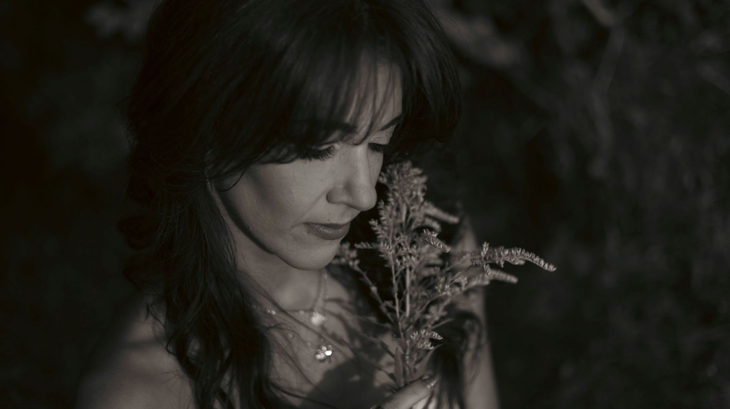 A collection of moody black and white portraits showing a person with flowers in a dramatic artistic style.