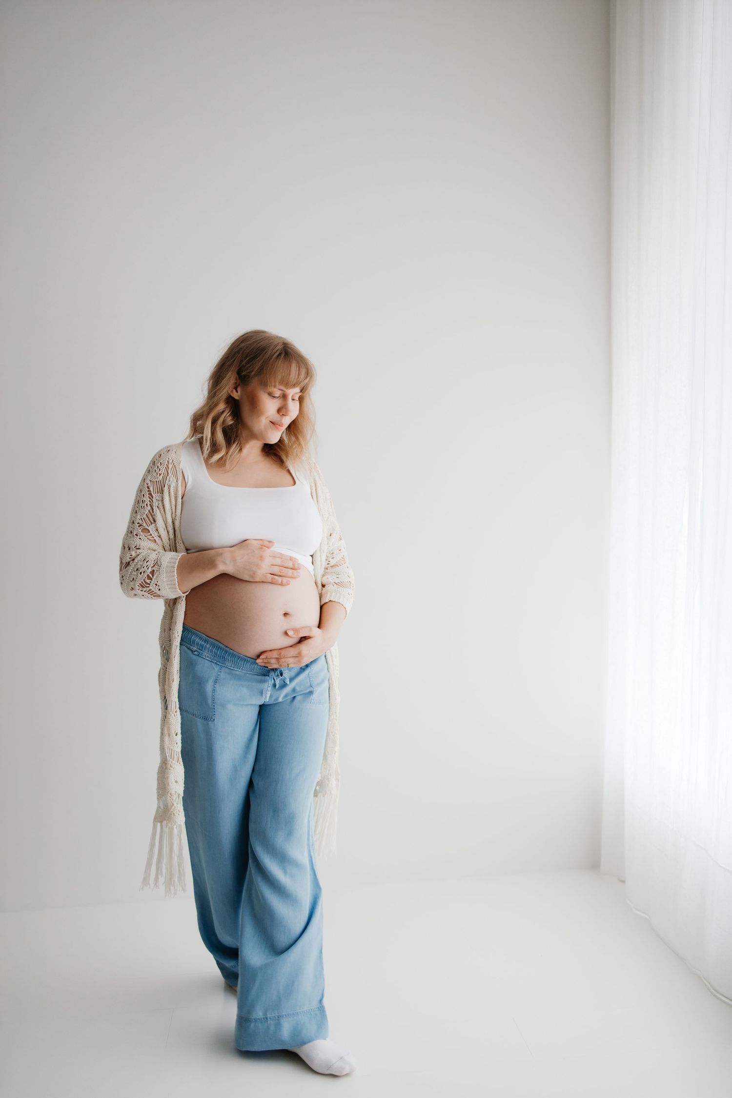 A series of black and white photos showing a pregnant woman's growing belly in different stages of pregnancy.