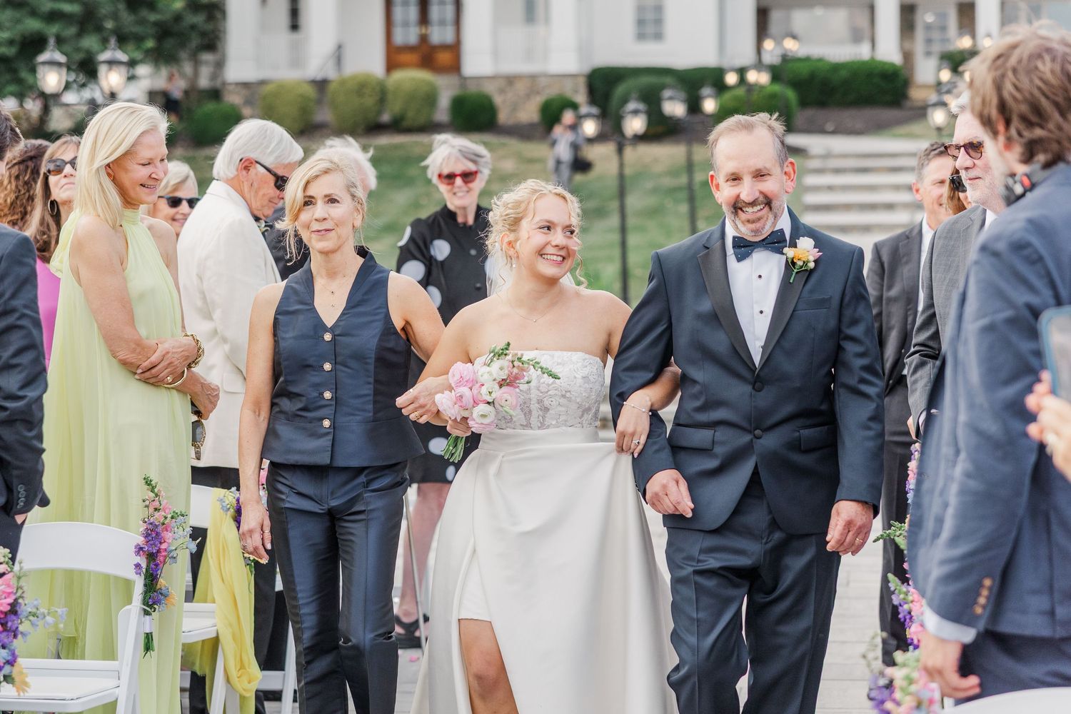 Wedding guests mingling on stone patio during outdoor celebration.
