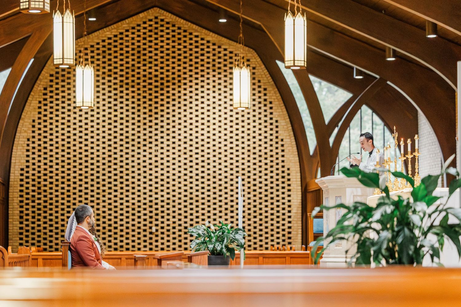Modern interior with wooden beams, pendant lights, and perforated wall panels creates warm architectural ambiance.
