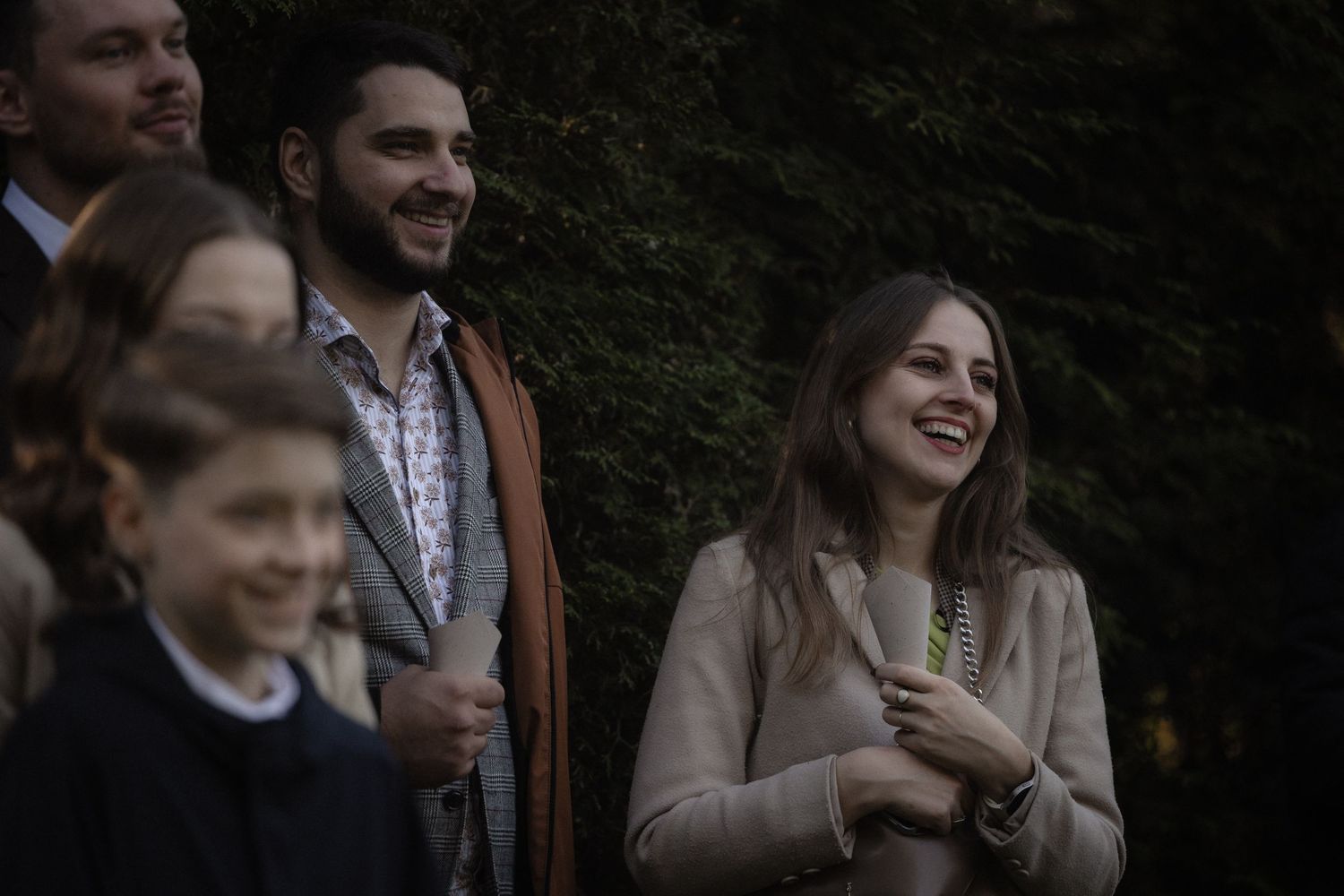 A group of people enjoying themselves at an outdoor gathering in a wooded setting.