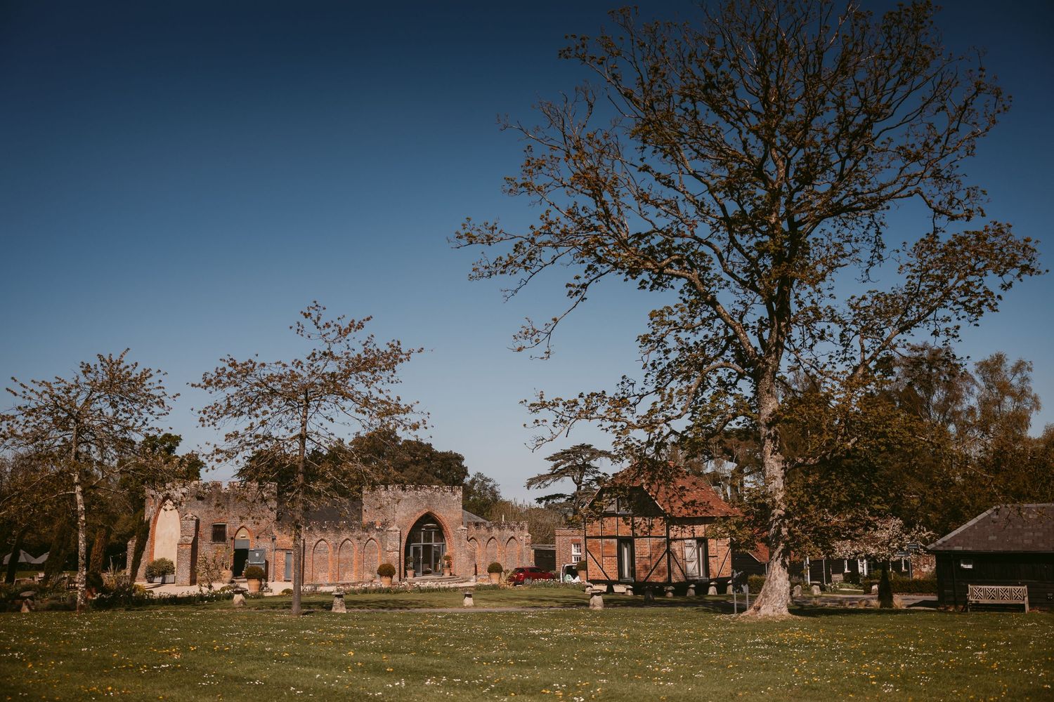 Panoramic view of historic stone church ruins and cemetery against a dramatic blue sky.