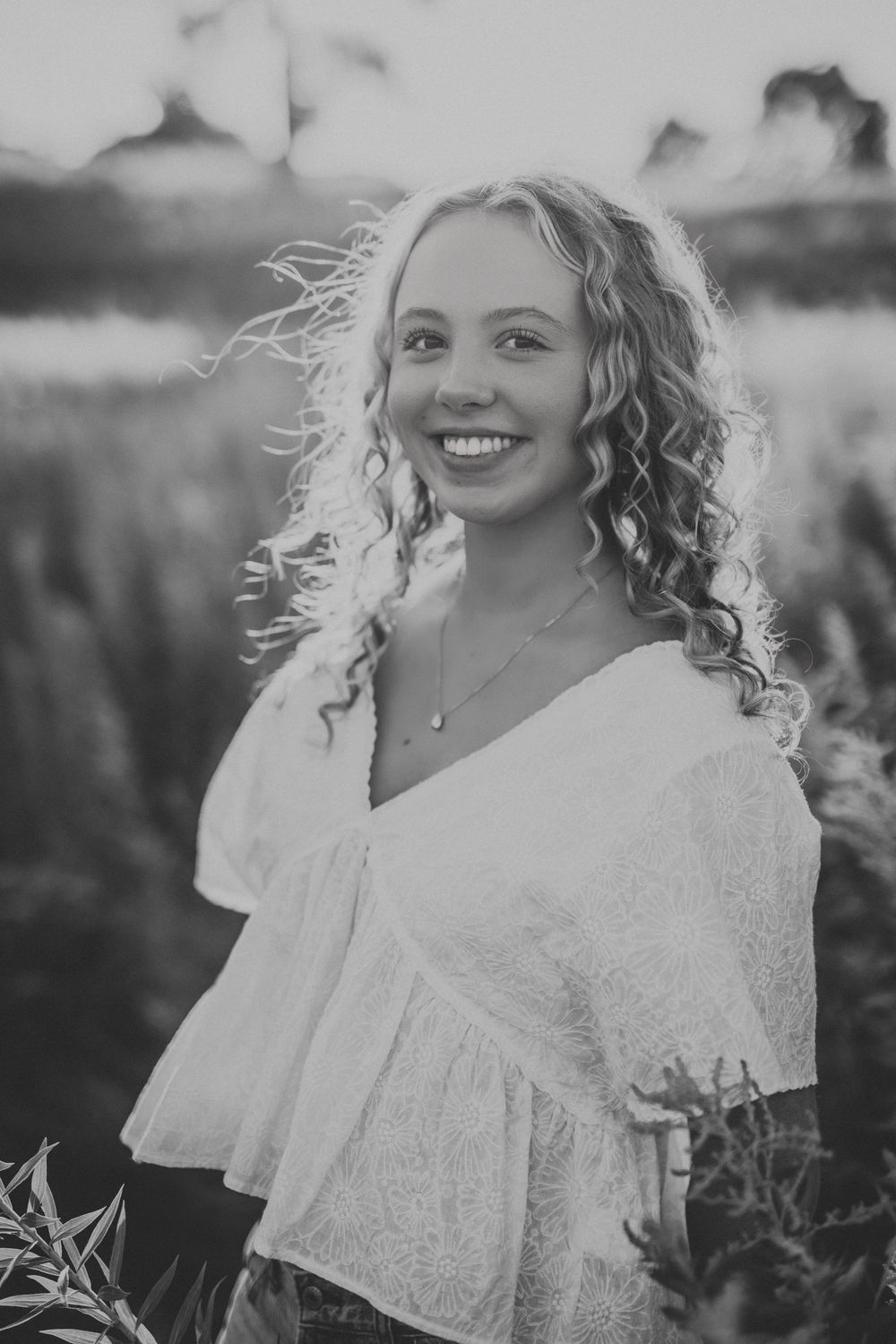 Black and white portrait series capturing joyful moments in a natural outdoor setting with soft lighting.