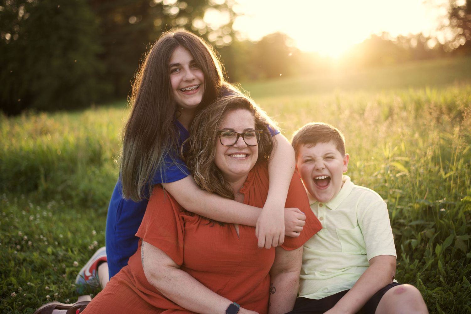 family enjoying each other's company; siblings, snuggles, sunset, laughing
