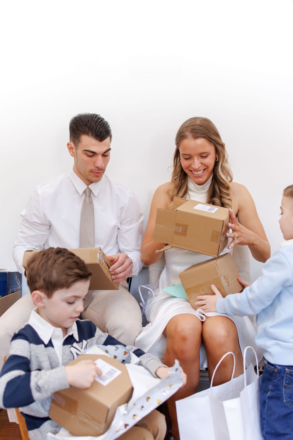 Young students in school uniforms opening packages and reading letters together in a classroom setting.
