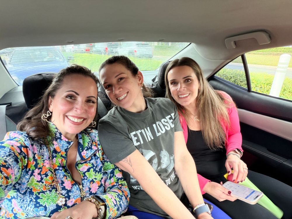 A group of friends taking selfies together while sitting headed to Disney World.