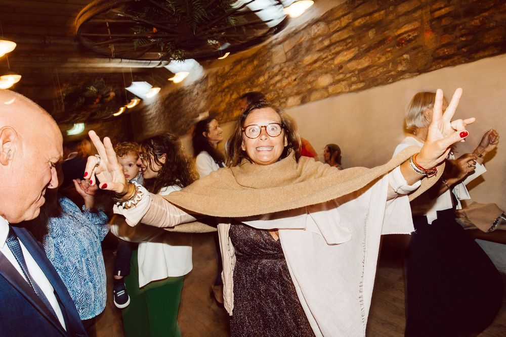 Wedding guests dance and celebrate together on a lively dance floor at an indoor reception venue.