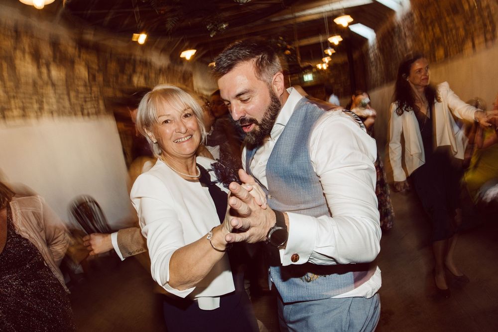 Dancers executing dynamic swing dance lifts and spins on a wooden dance floor.
