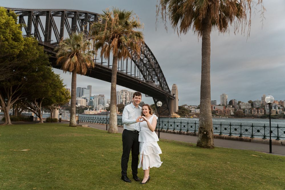 Scenic wedding photos captured along Sydney Harbour with iconic Bridge and palm trees in the background engagement photoshoot