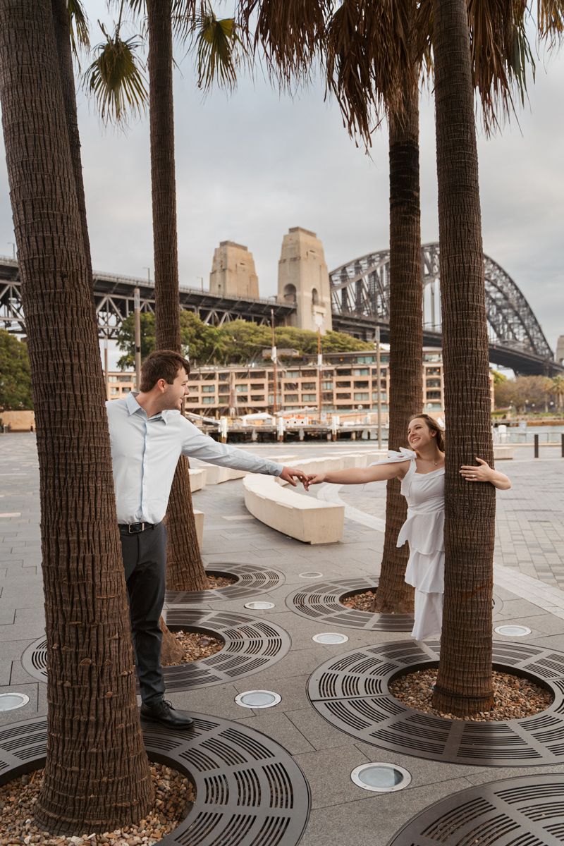 A romantic photoshoot at Sydney Opera House with palm trees and iconic Harbour Bridge in the background