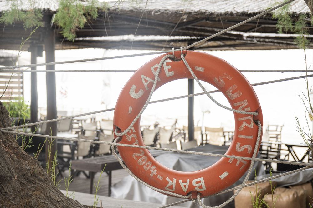 A collection of vintage life preservers and boat equipment arranged in a nautical-themed display against white walls.