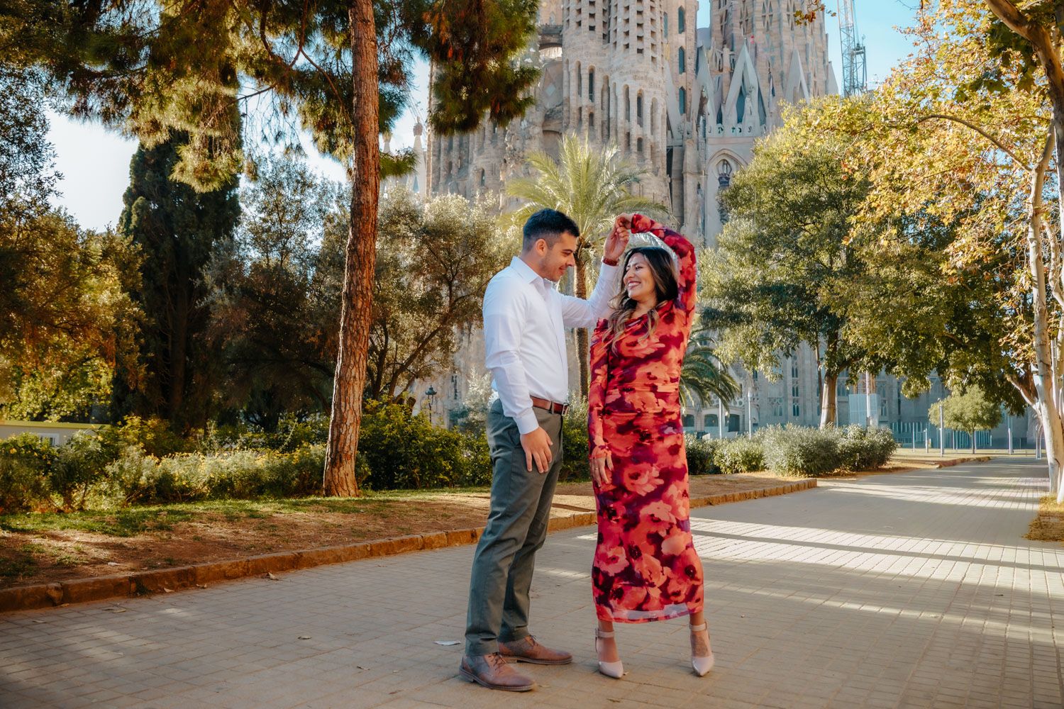 Couple kissing after engagement in Barcelona with Sagrada Familia behind