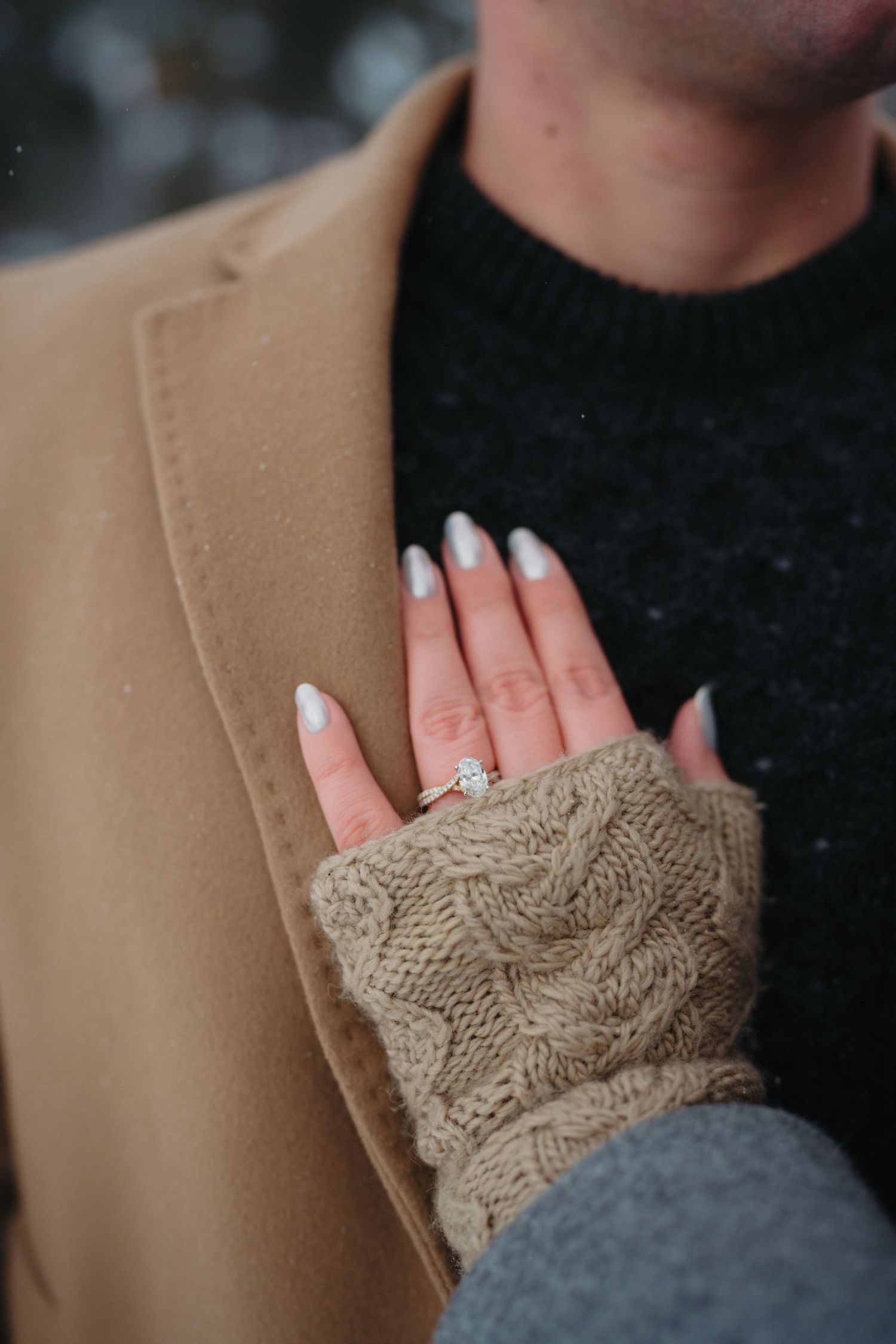 Close-up sequence showing a knitted beige fingerless glove with cable pattern detail on a person wearing black clothing.