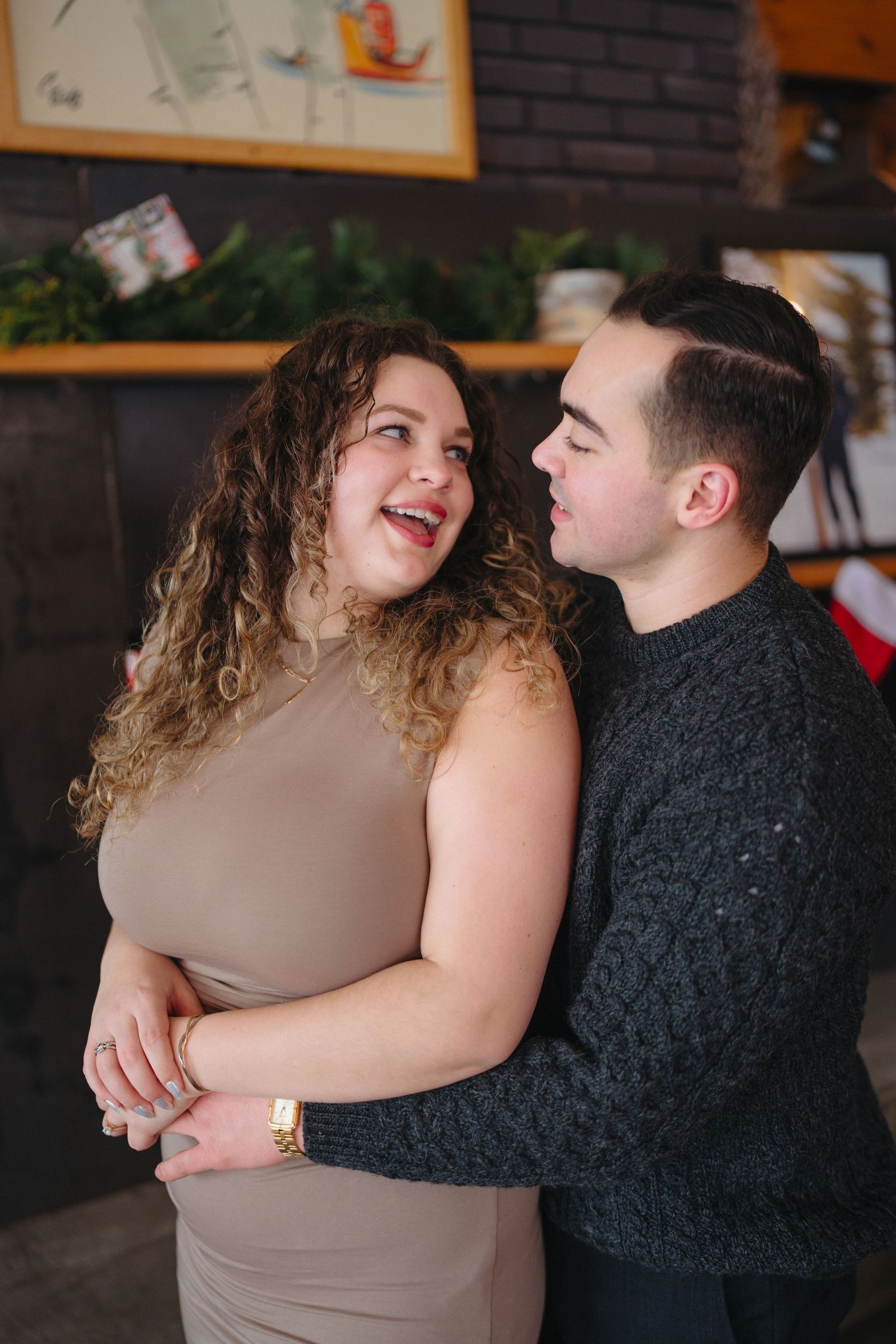 A joyful couple sharing an intimate moment and laughing together in a cozy indoor setting.