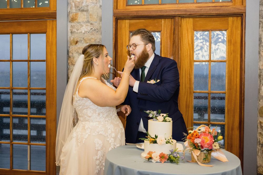 Wedding ceremony in rustic venue with wooden windows and stone walls decorated with romantic lighting.