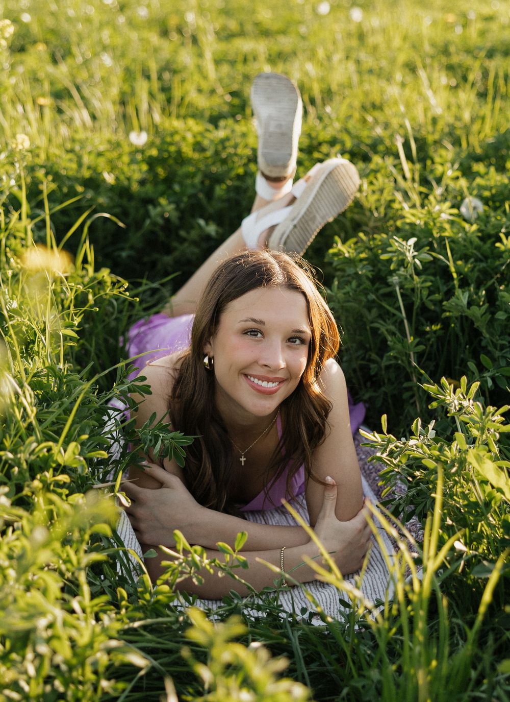Outdoor photography in tall grass and wildflowers during golden hour with soft natural lighting.