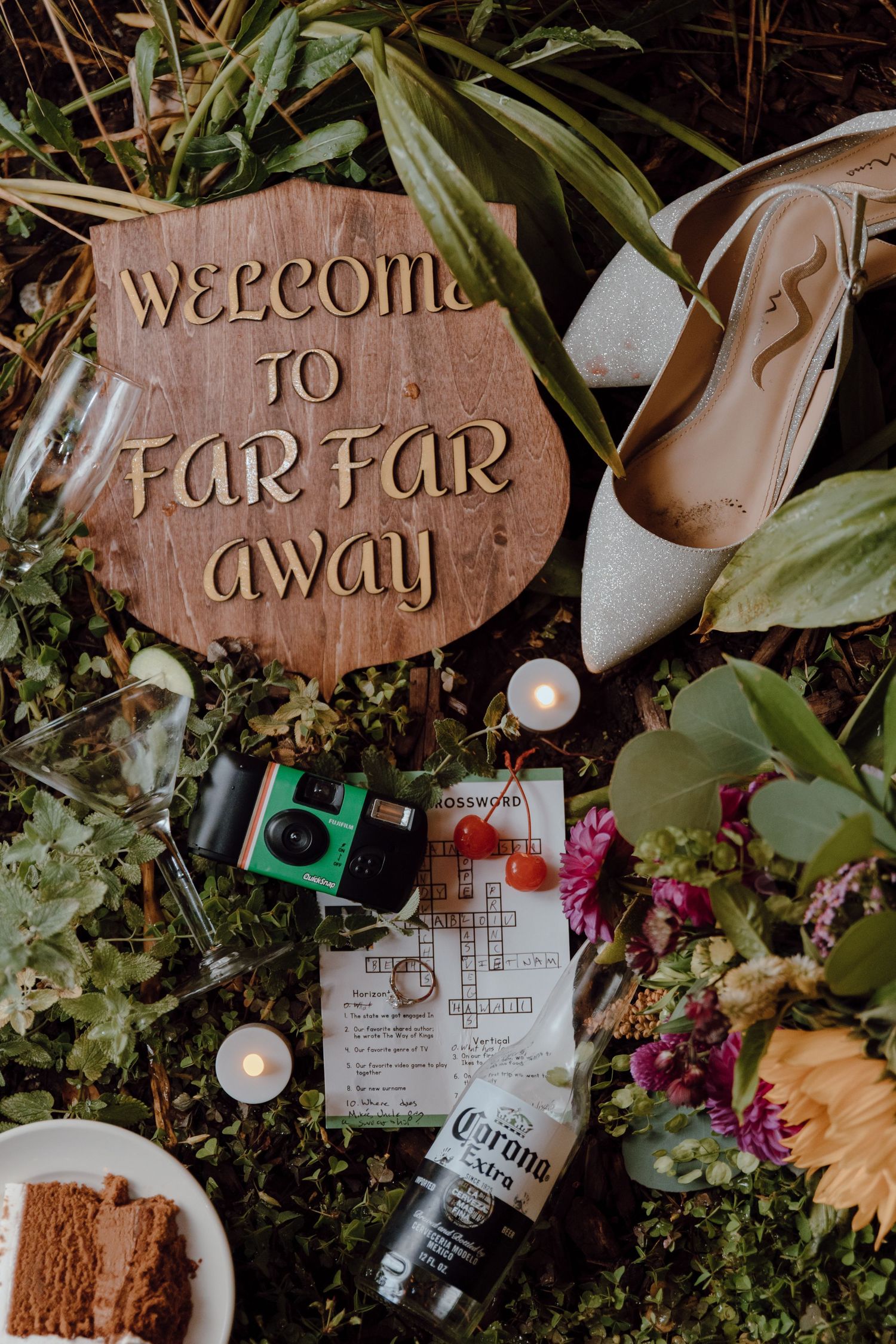Rustic wooden welcome sign surrounded by greenery, flowers, and bottles in a whimsical garden party setting.