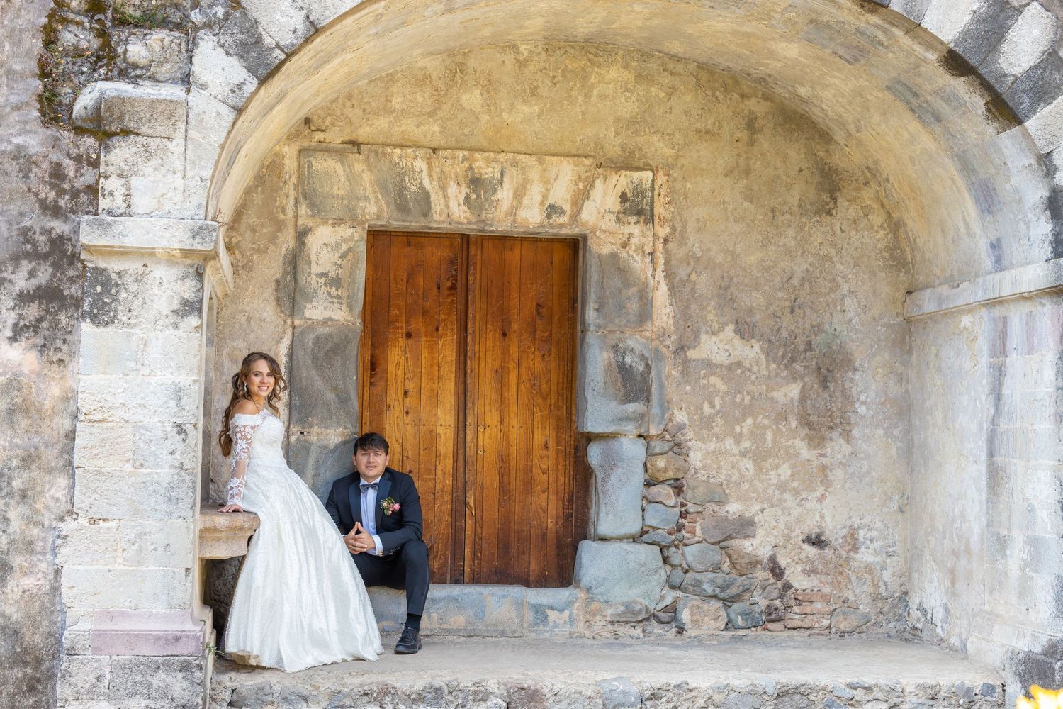 Couple in formal wedding attire embracing and dancing together in an elegant setting.