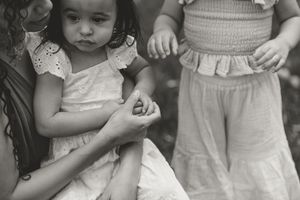A series of vintage black and white photographs showing children in light-colored dresses and clothing.