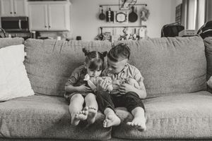 A black and white photo collage showing a sequence of someone sitting on a couch with a small dog.