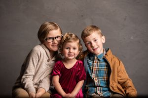 A series of professional studio portraits against a gray backdrop showing a family in coordinated casual attire.