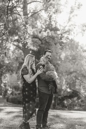 Black and white photo sequence showing playful couple laughing together outdoors in a natural setting.