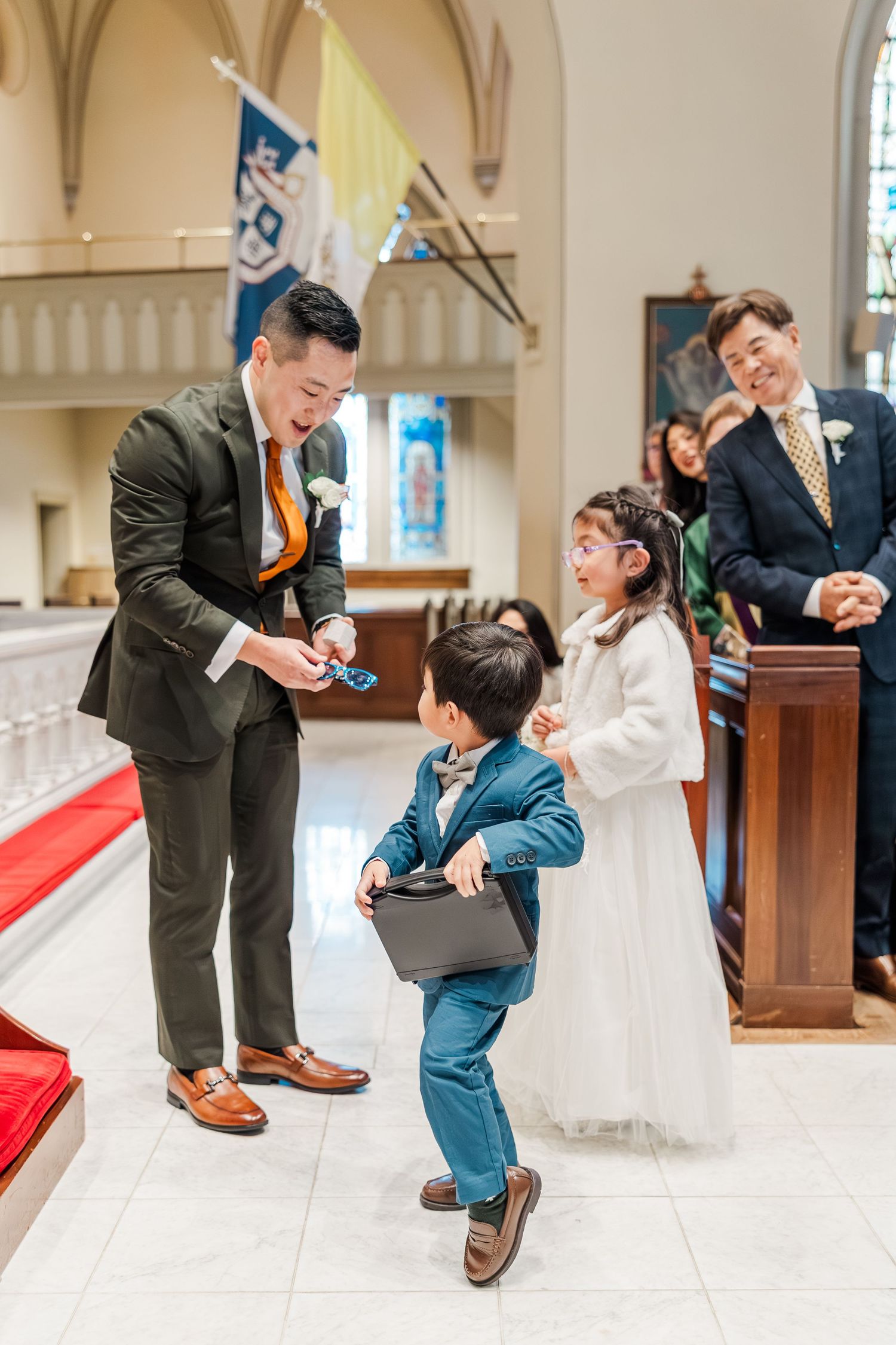 A joyful moment captured during a wedding ceremony in a church with people sharing laughter on the altar steps.