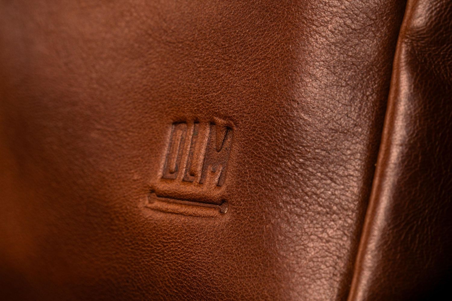 Detalle cercano de cuero premium mostrando textura y estampado de marca.
