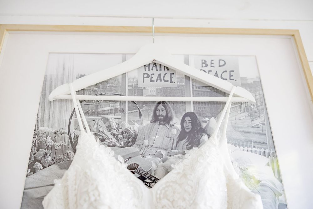 Wedding dress detail with framed vintage photograph displayed above.
