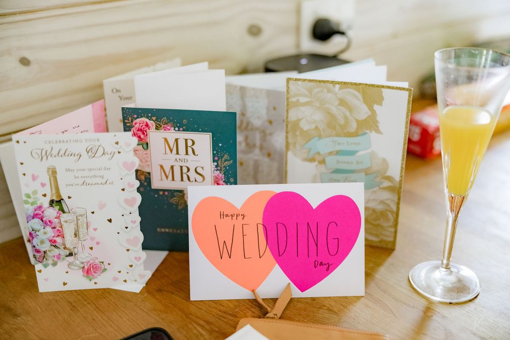 Wedding cards and congratulatory notes displayed next to a champagne glass.