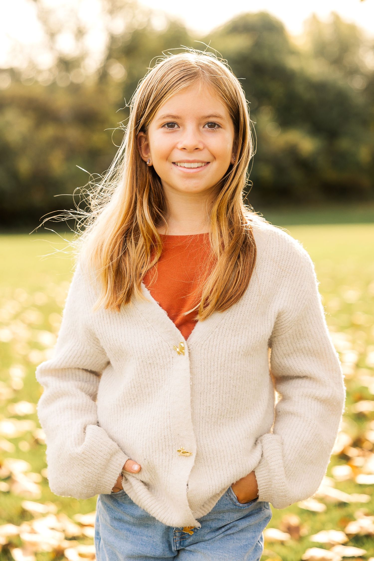 Portrait in autumn field wearing cream cardigan and orange shirt. Novi Northville Portrait Photographer