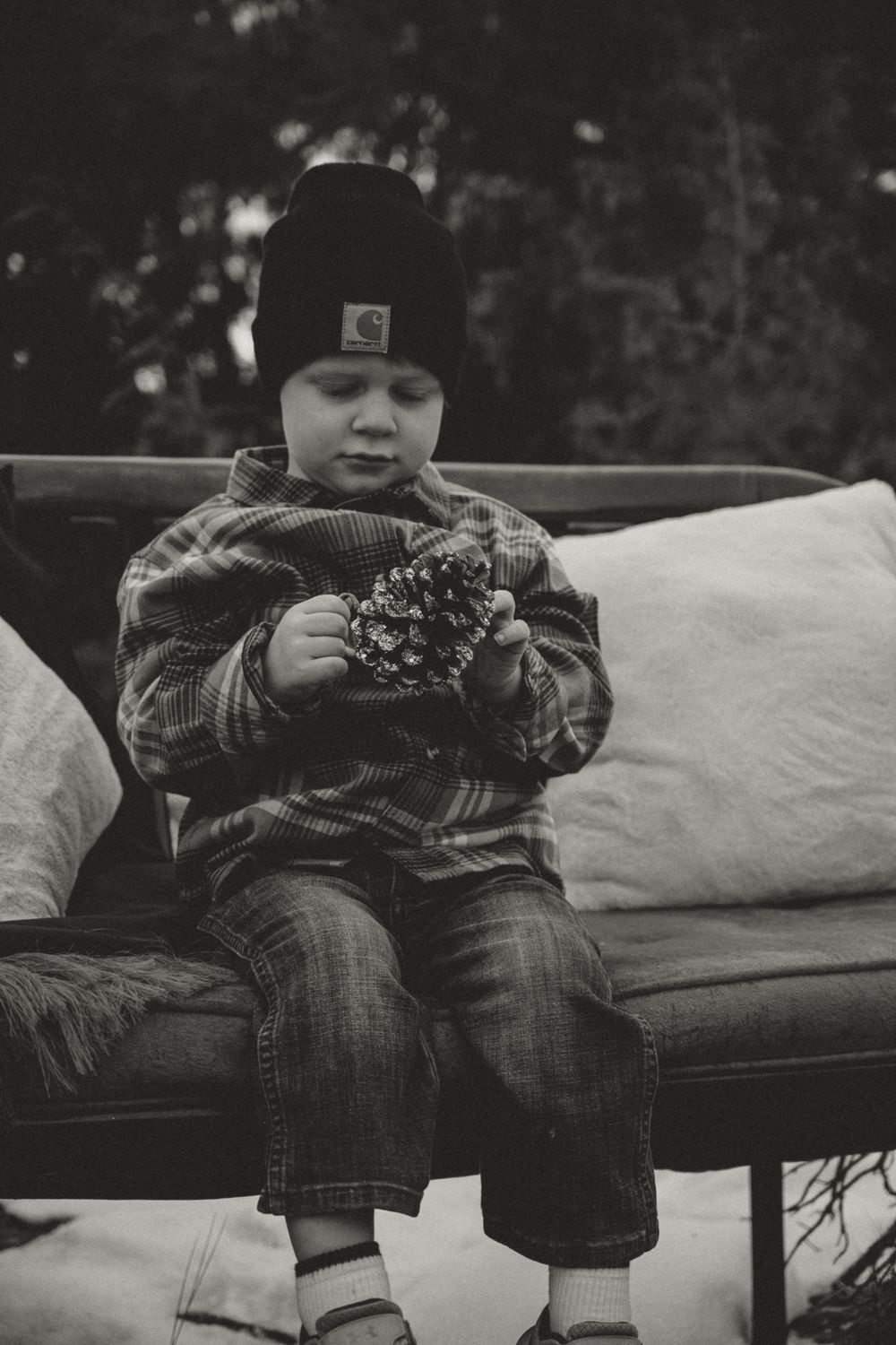 Black and white photo of children relaxing on cushions during an outdoor photo session.