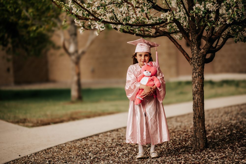 Person in pink dress twirls under blooming spring trees.