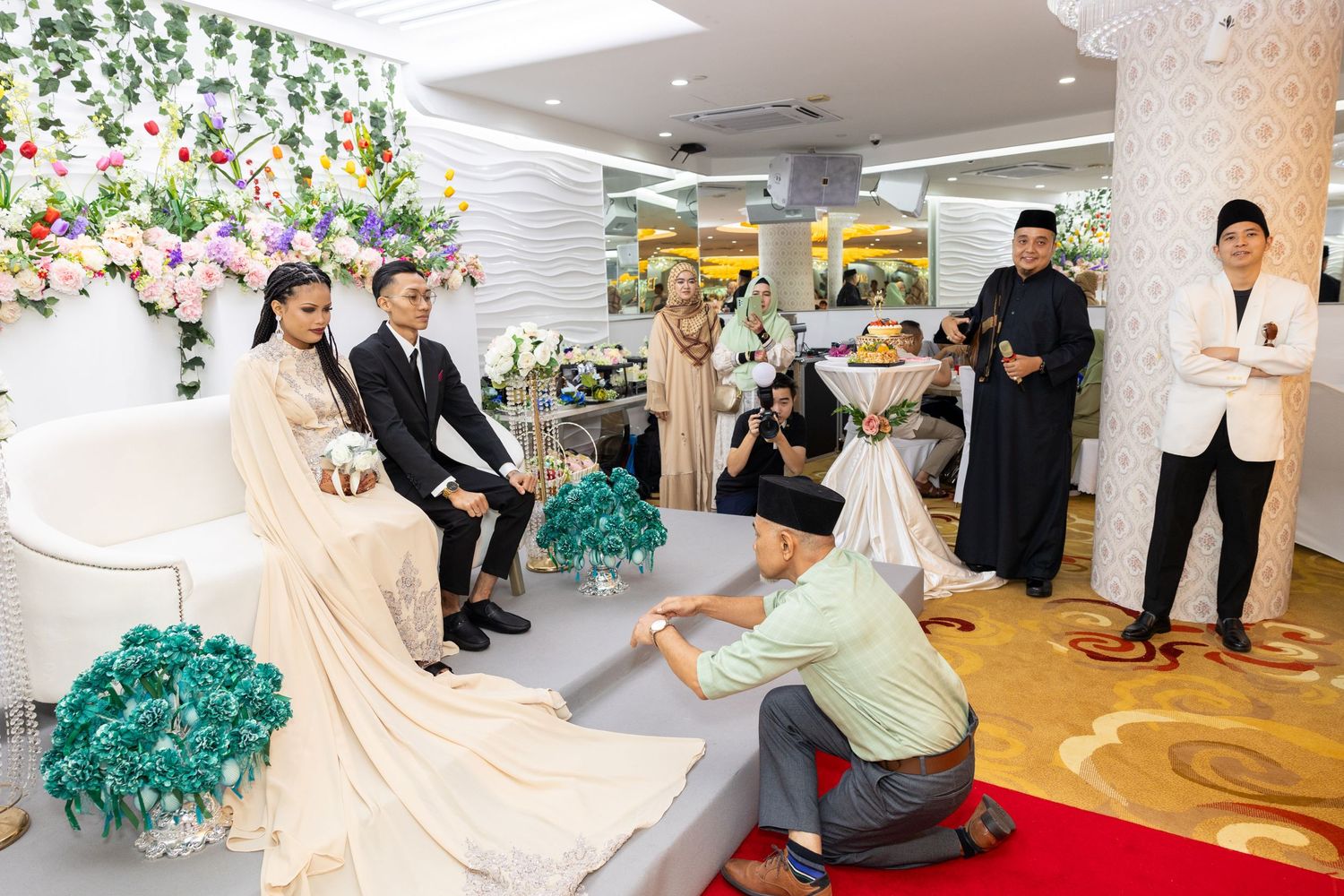 Wedding ceremony setup with traditional floor seating and floral decorations.