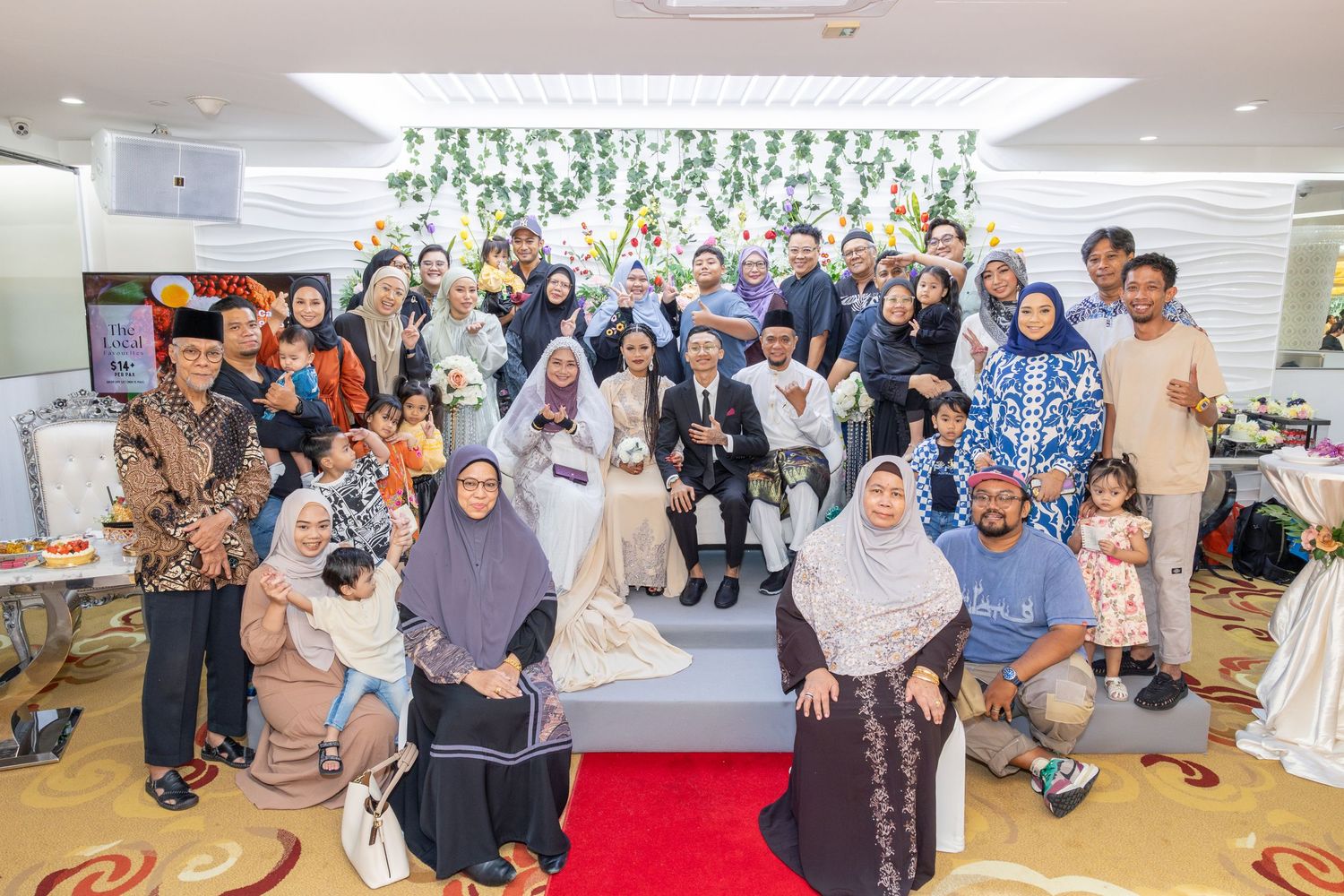 Large group reception photo with guests in traditional attire.