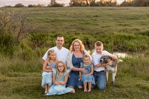 family of six sitting in pasture