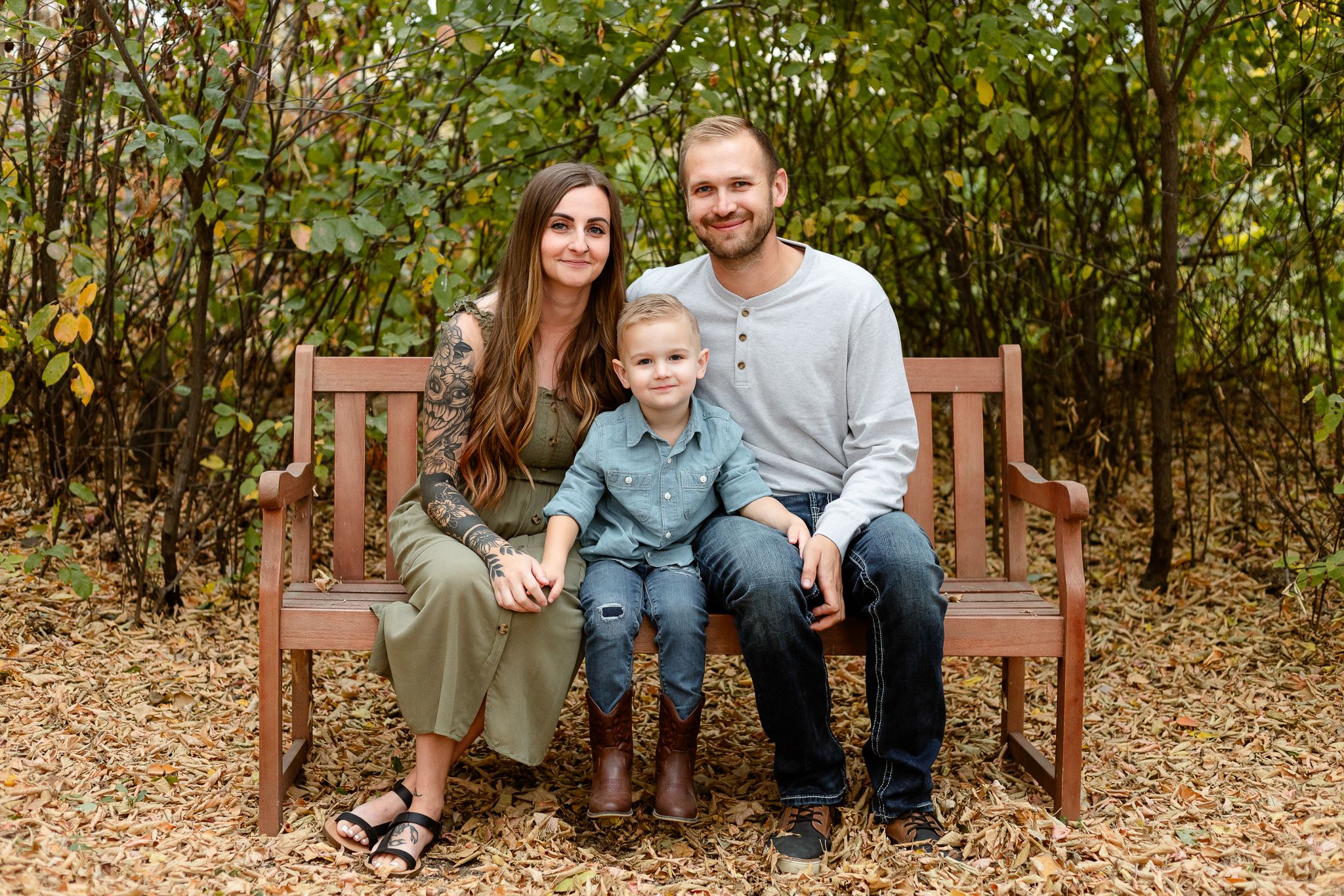 family of three sitting on bench