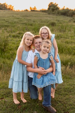 brother with three sisters exploring cow pasture