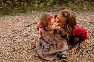 sister showing affection to baby